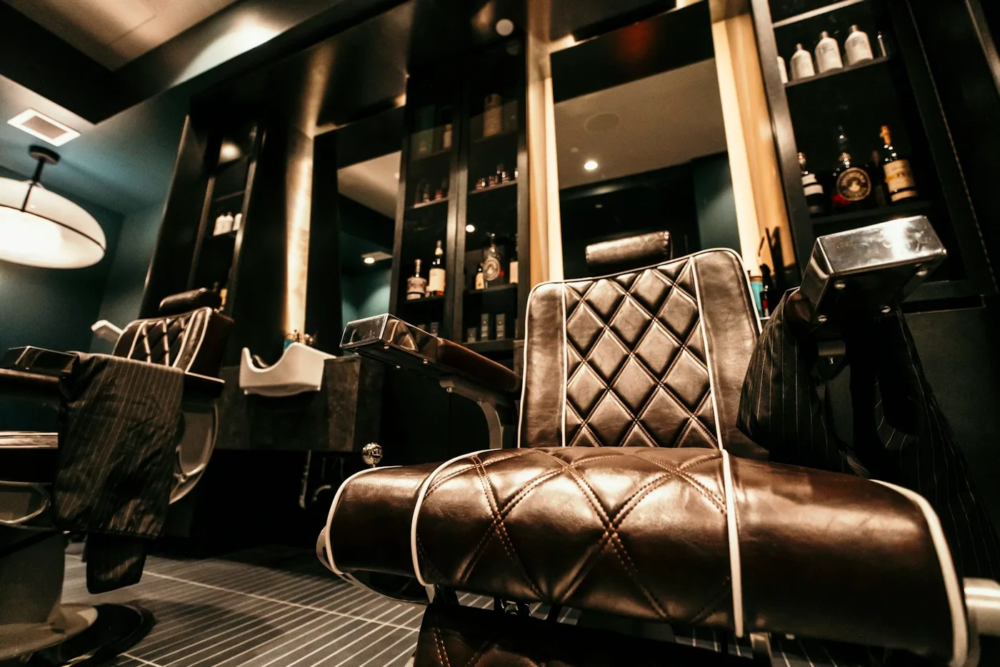 Cadeiras e espelhos de uma barbearia contemporânea em fotografia de banco.