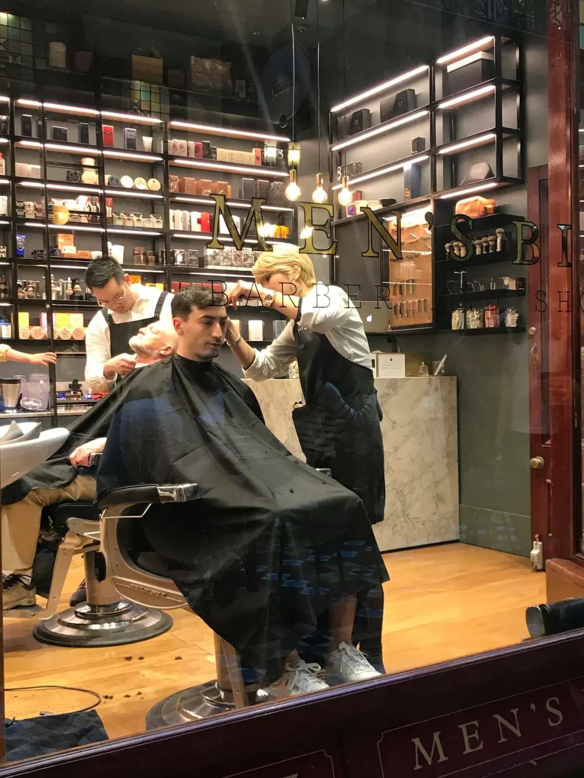Profissionais trabalhando em uma barbearia em fotografia de banco.